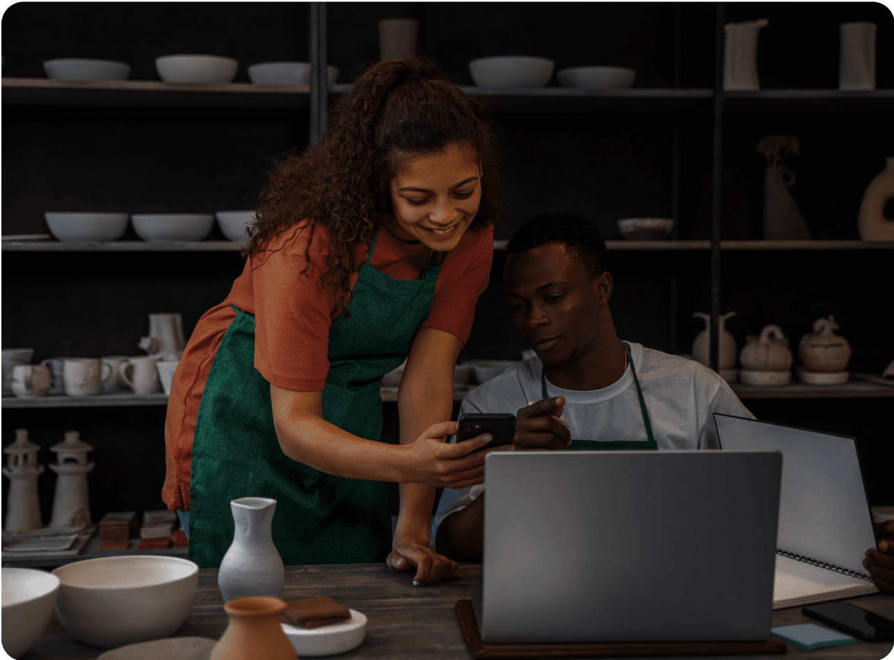 Small business owners reviewing finances on a laptop, highlighting outsourcing accounting services