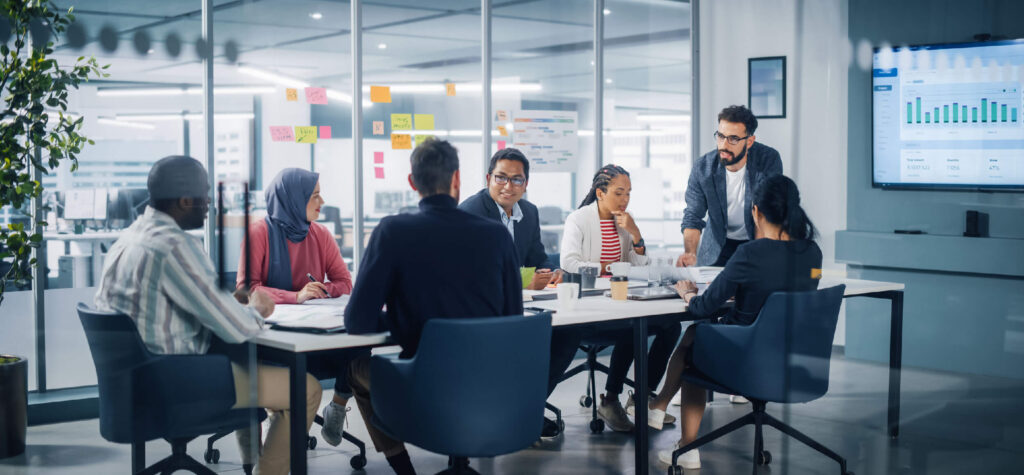 Finance team analyzing real-time data and forecasts on digital dashboards during an NSPB planning meeting